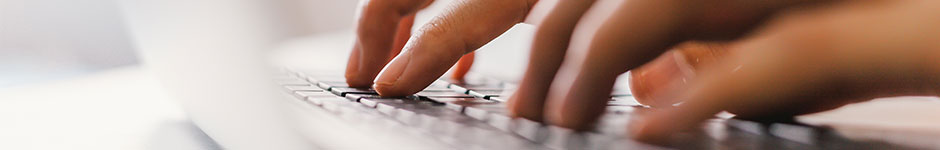 Close up of hands typing on a laptop keyboard