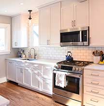 Small kitchen renovated with white cabinets by Omega